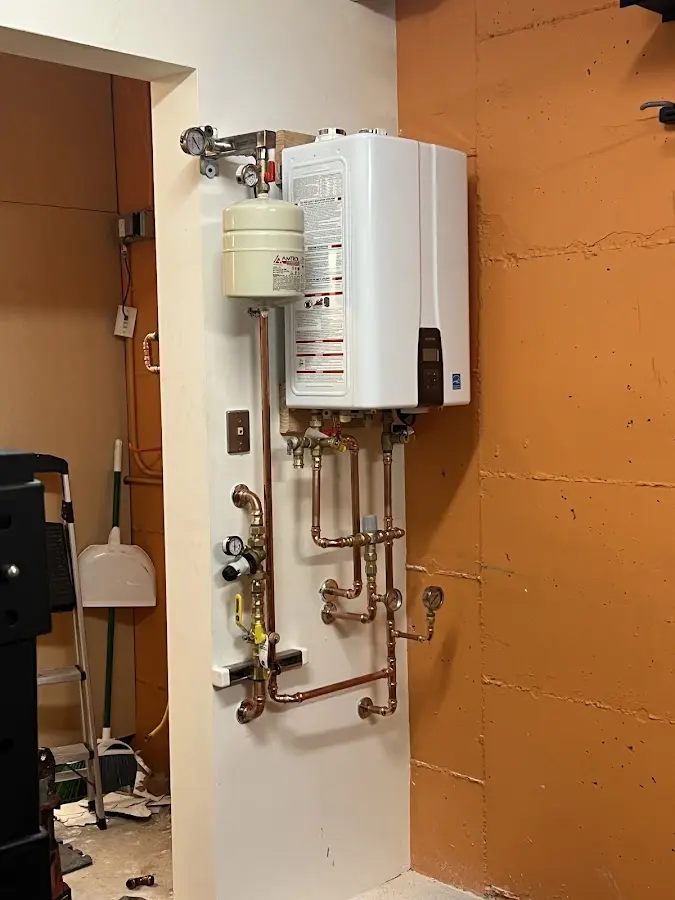 Plumbing technician inspecting water heater connections in Green Level